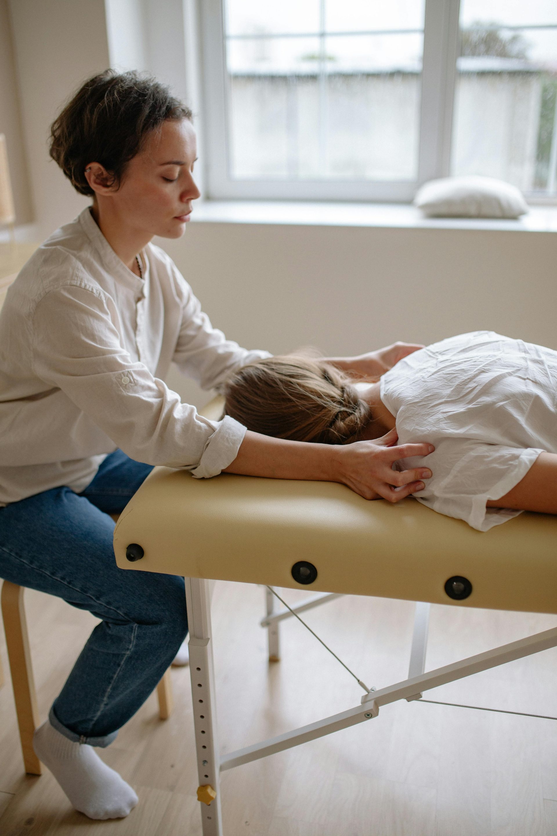 Une séance de massage apaisante axée sur la relaxation et le bien-être dans un spa à l'éclairage tamisé.